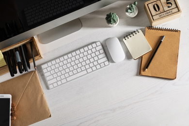 Designer's workplace with modern computer and stationery, flat lay. Space for text