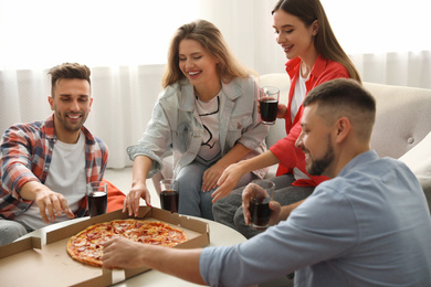 Group of friends eating tasty pizza at home