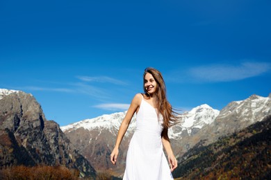 Photo of Young woman walking in beautiful mountains on sunny day