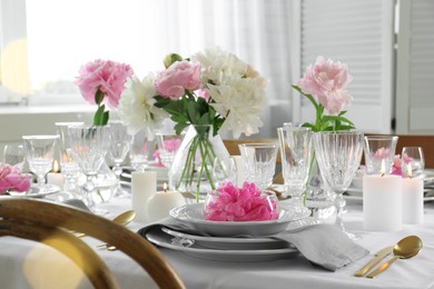 Photo of Stylish table setting with beautiful peonies in dining room. Bokeh effect