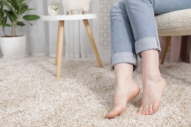 Photo of Woman sitting in armchair at home, closeup. Space for text