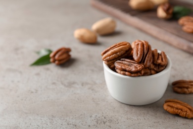 Photo of Shelled pecan nuts in bowl on table. Space for text