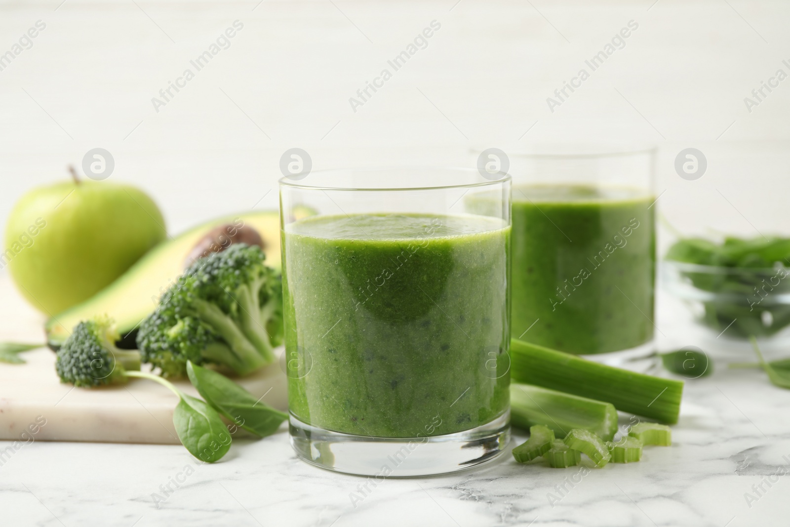 Photo of Delicious fresh green juice on white marble table