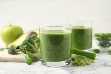 Delicious fresh green juice on white marble table