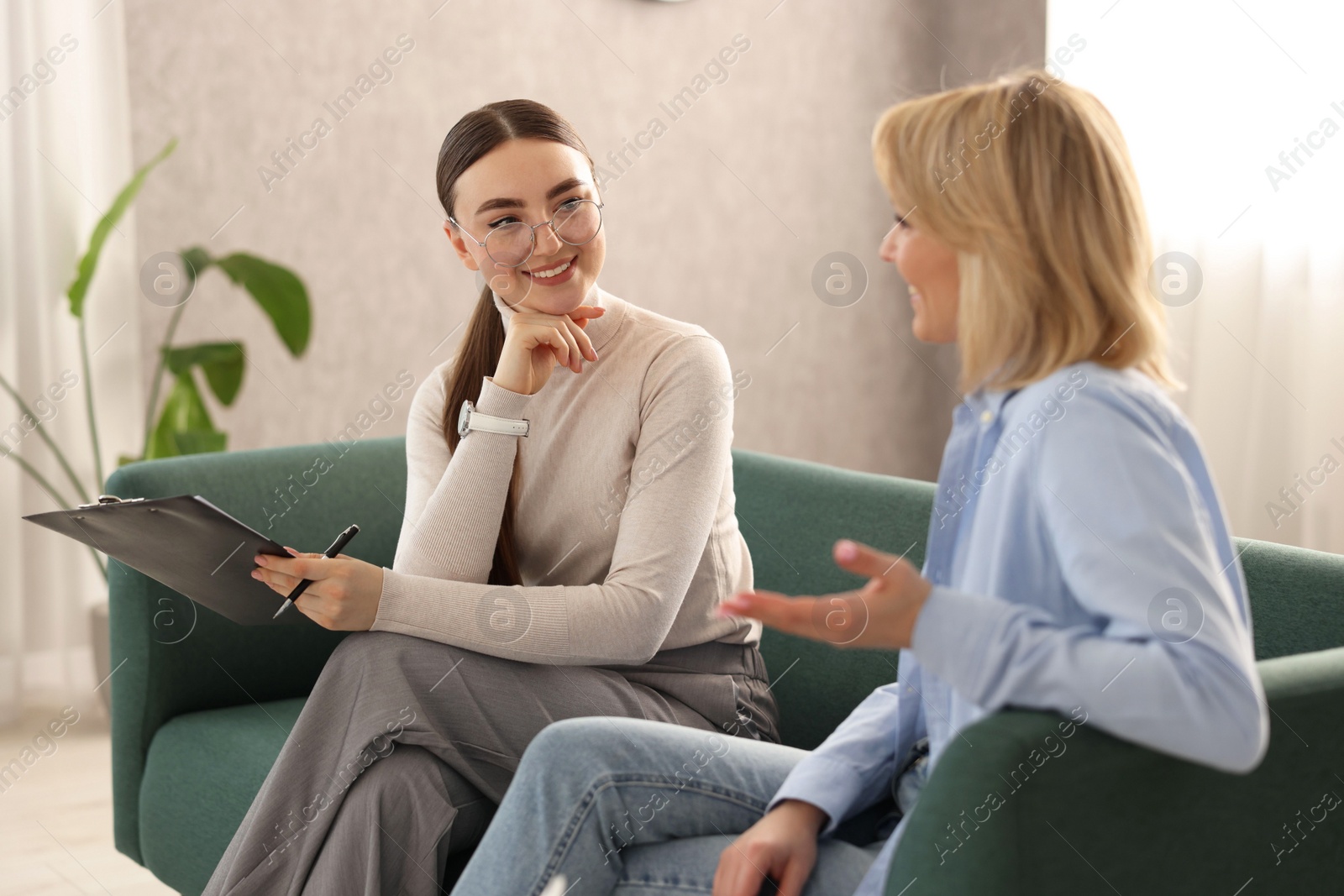 Photo of Psychotherapist working with patient on sofa in office