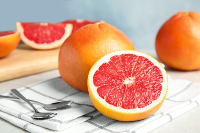 Photo of Fresh grapefruits on table against color background