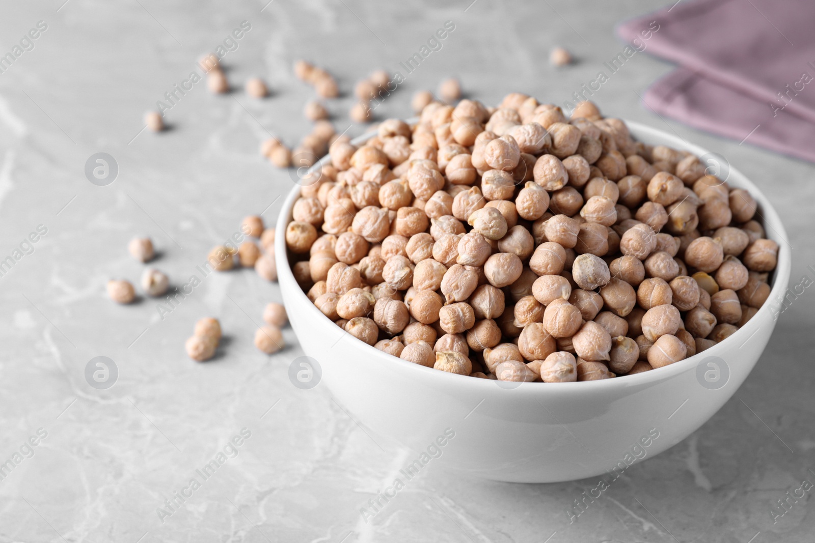 Photo of Chickpeas in bowl on light grey table, space for text