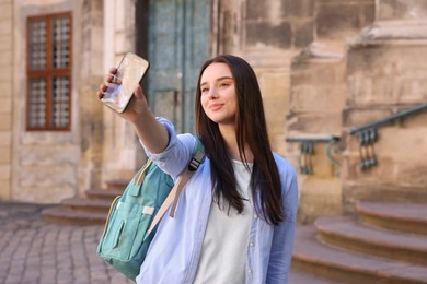 Photo of Beautiful travel blogger with smartphone streaming outdoors