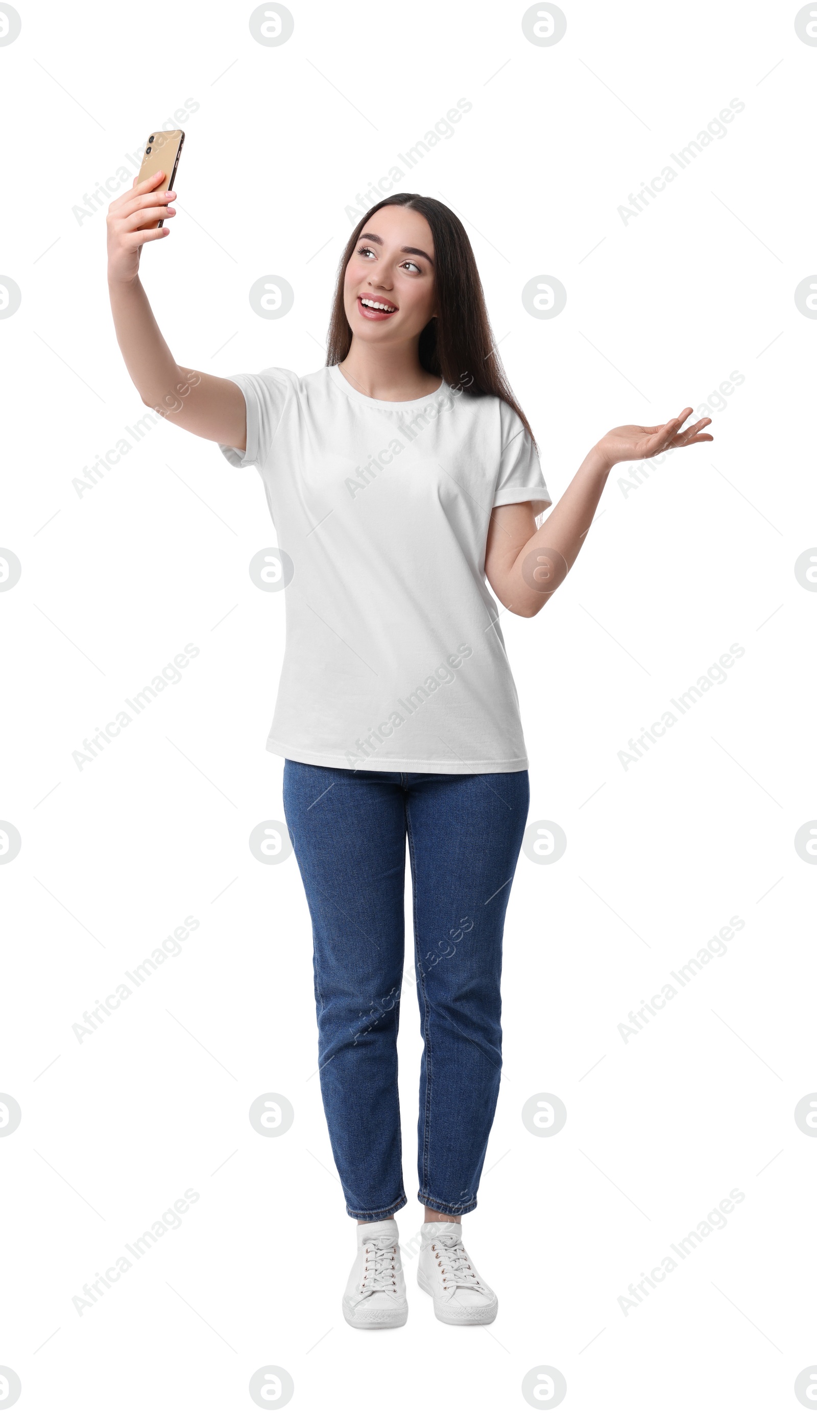 Photo of Smiling young woman taking selfie with smartphone on white background