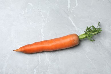 Photo of Fresh ripe juicy carrot on light grey marble table, top view