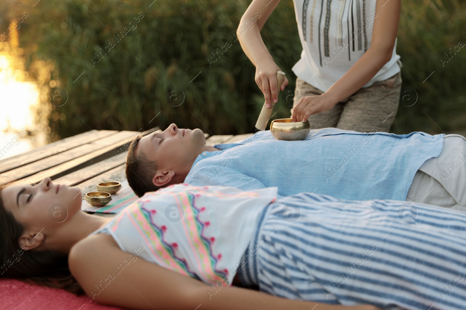 Photo of Couple at healing session with singing bowl outdoors