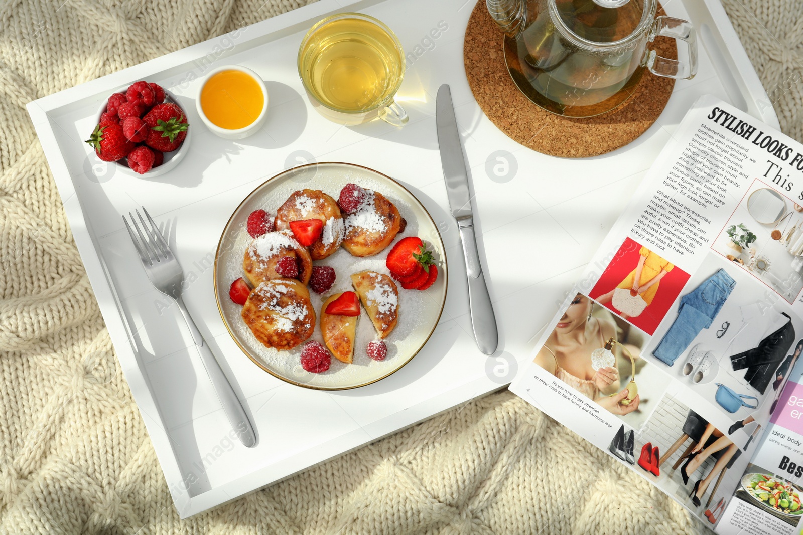 Photo of Delicious cottage cheese pancakes with fresh berries and powdered sugar served on wooden tray, top view