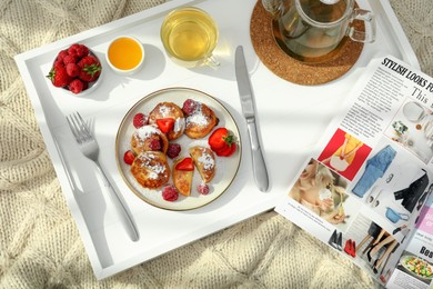 Photo of Delicious cottage cheese pancakes with fresh berries and powdered sugar served on wooden tray, top view