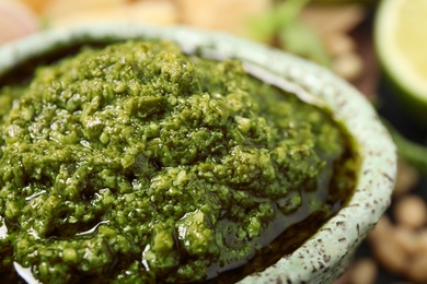 Bowl of tasty arugula pesto, closeup view