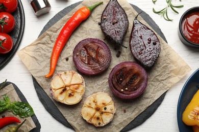 Delicious grilled vegetables served on white wooden table, flat lay