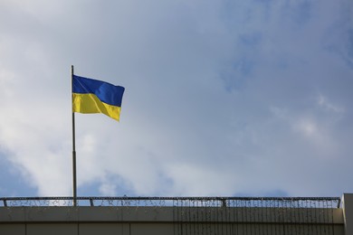 Photo of Ukrainian flag on building against cloudy sky
