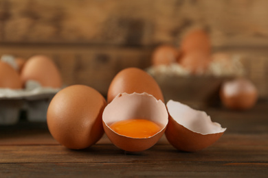 Photo of Raw brown chicken eggs on wooden table