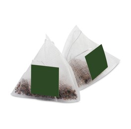 Photo of New pyramid tea bags on white background