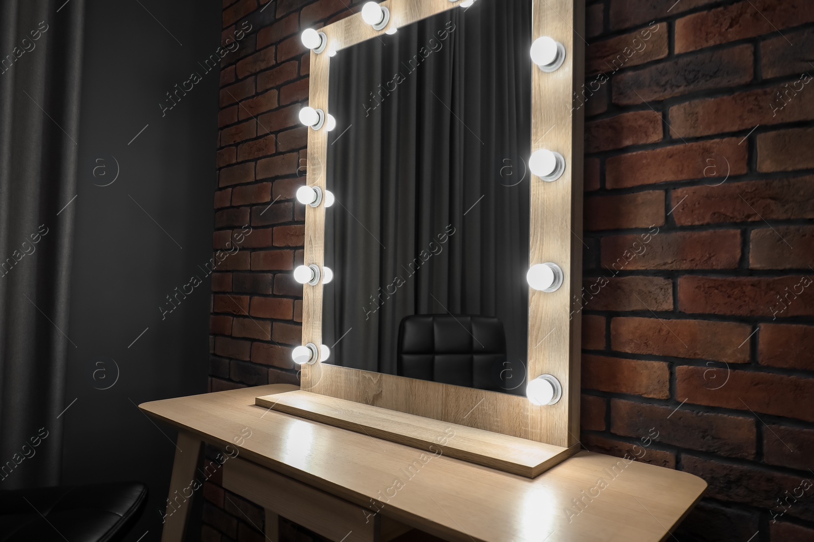 Photo of Mirror with light bulbs and table in makeup room