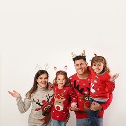 Family in Christmas sweaters and festive headbands on white background