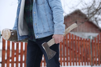 Man with axe and wood outdoors on winter day, closeup. Space for text