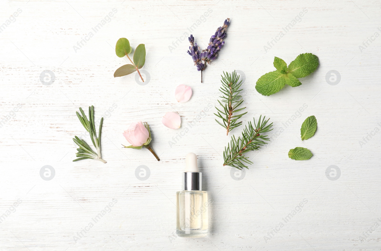 Photo of Essential oil and ingredients on wooden background, flat lay