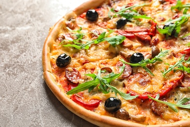 Delicious pizza with olives and sausages on table