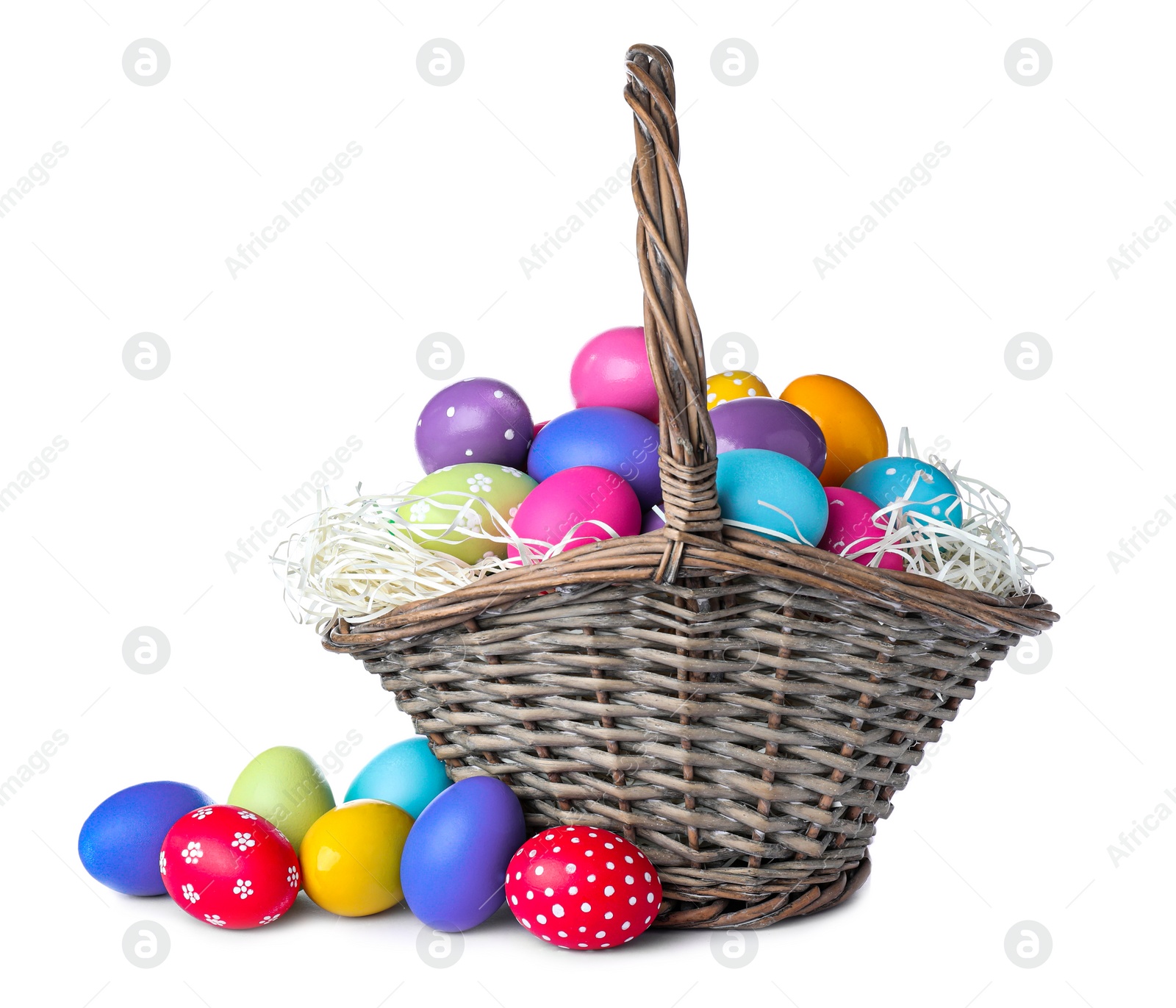 Photo of Wicker basket with bright painted Easter eggs on white background