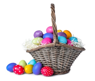 Wicker basket with bright painted Easter eggs on white background