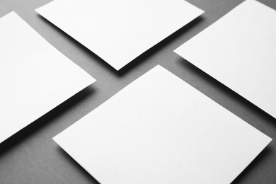 Photo of Blank note papers on dark grey background, closeup. Mock up for design