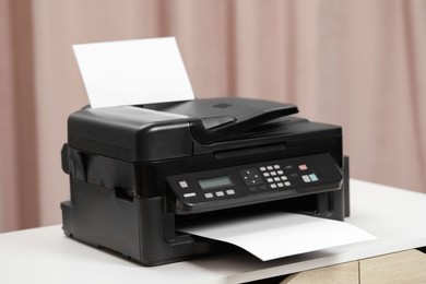 Photo of Modern printer with paper on white table indoors