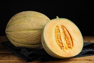 Photo of Tasty fresh melons on wooden table, closeup