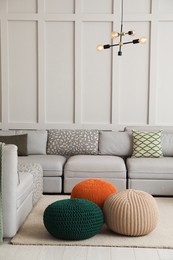 Living room interior with different stylish knitted poufs and sofa