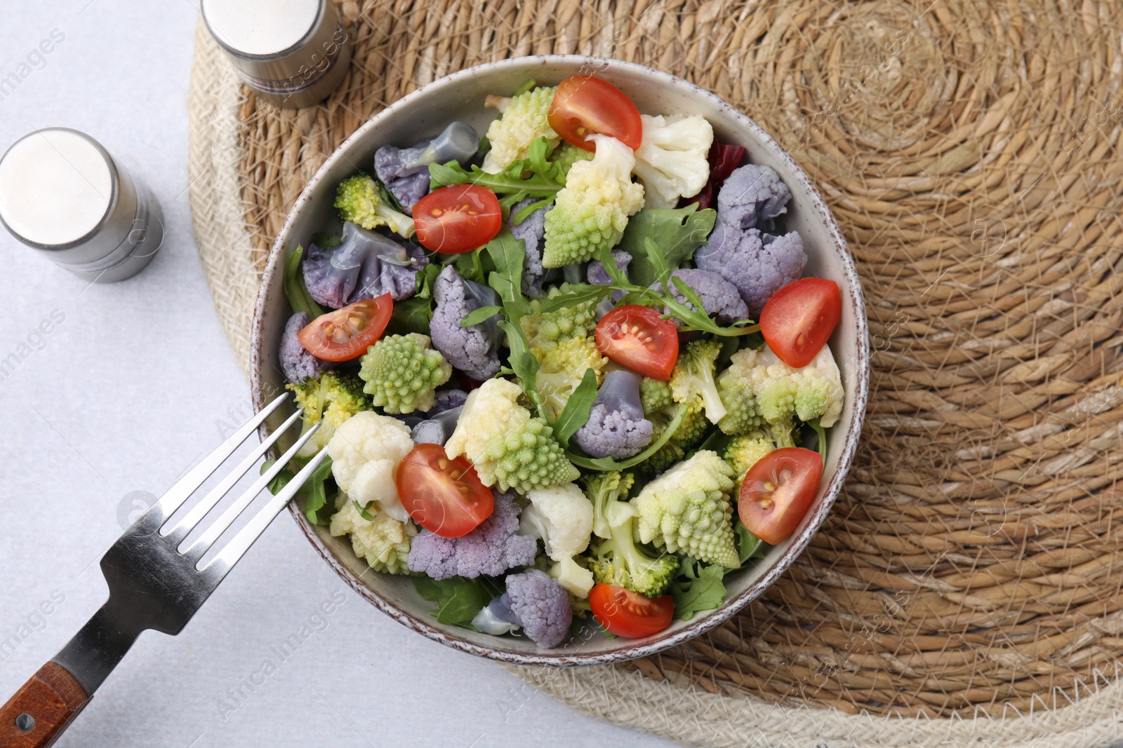 Photo of Delicious salad with cauliflower and tomato served on white table, flat lay