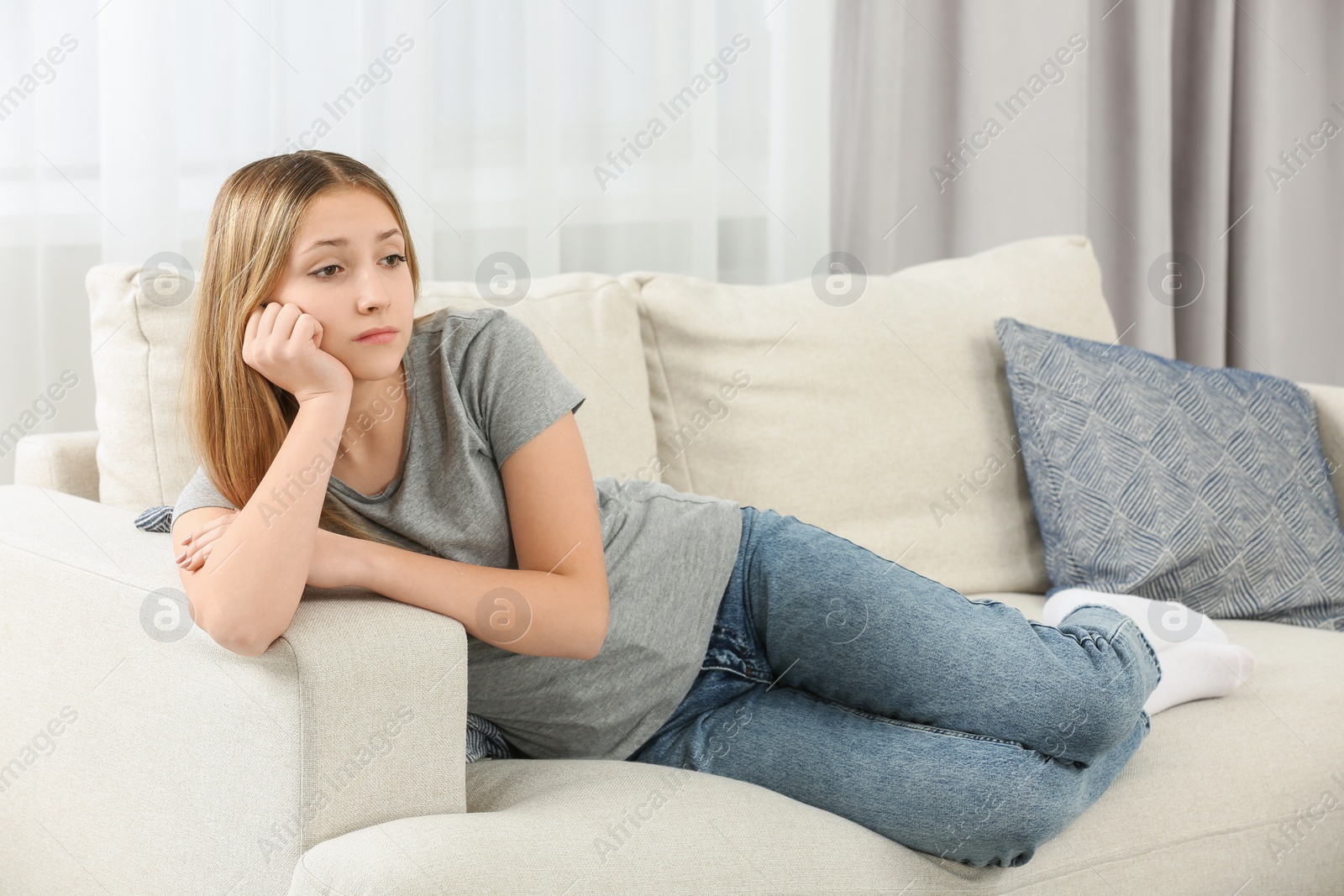 Photo of Upset teenage girl on sofa at home