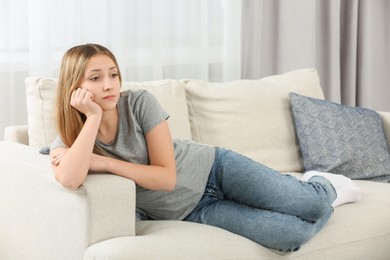 Photo of Upset teenage girl on sofa at home