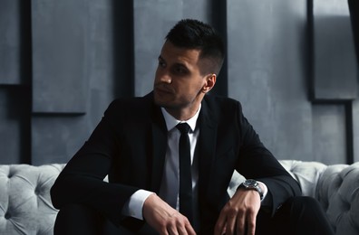 Photo of Handsome businessman on sofa indoors. Luxury lifestyle