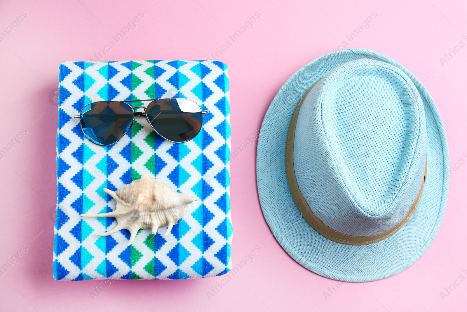 Photo of Flat lay composition with sunglasses and beach accessories on pink background