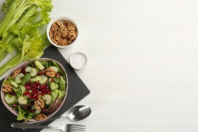 Delicious fresh celery salad served on white wooden table, flat lay. Space for text