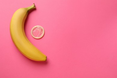 Photo of Banana and condom on pink background, flat lay with space for text. Safe sex concept