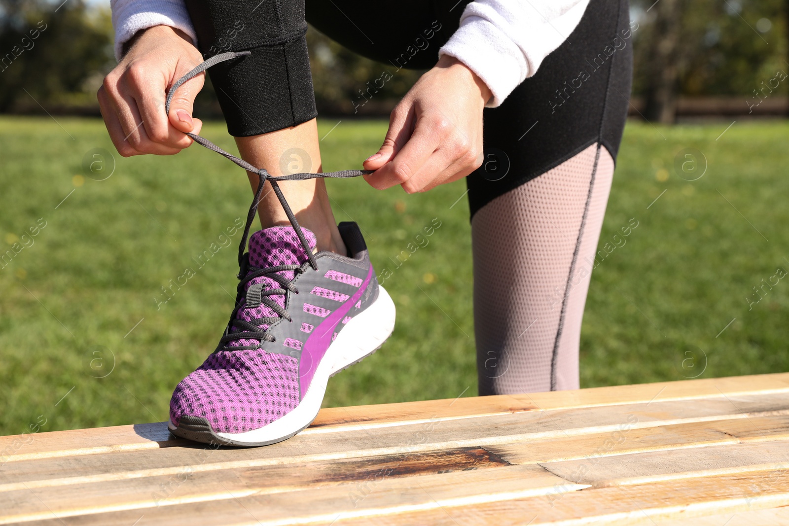 Photo of Sporty woman tying shoelaces before running outdoors