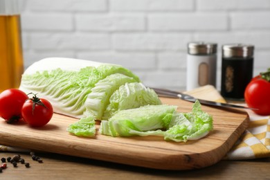 Photo of Cut fresh Chinese cabbage, tomatoes and spices on wooden table