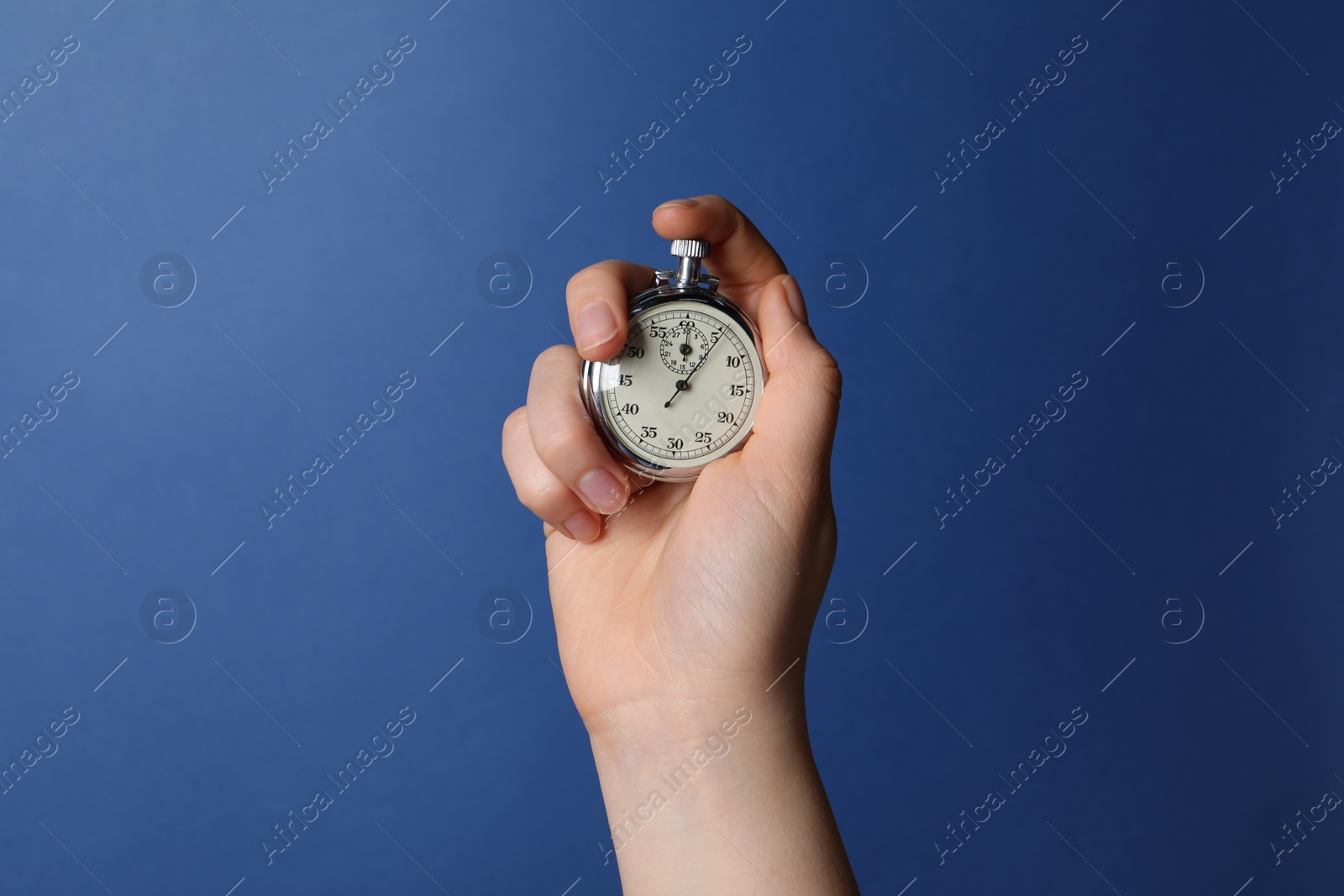 Photo of Woman holding vintage timer on blue background, closeup