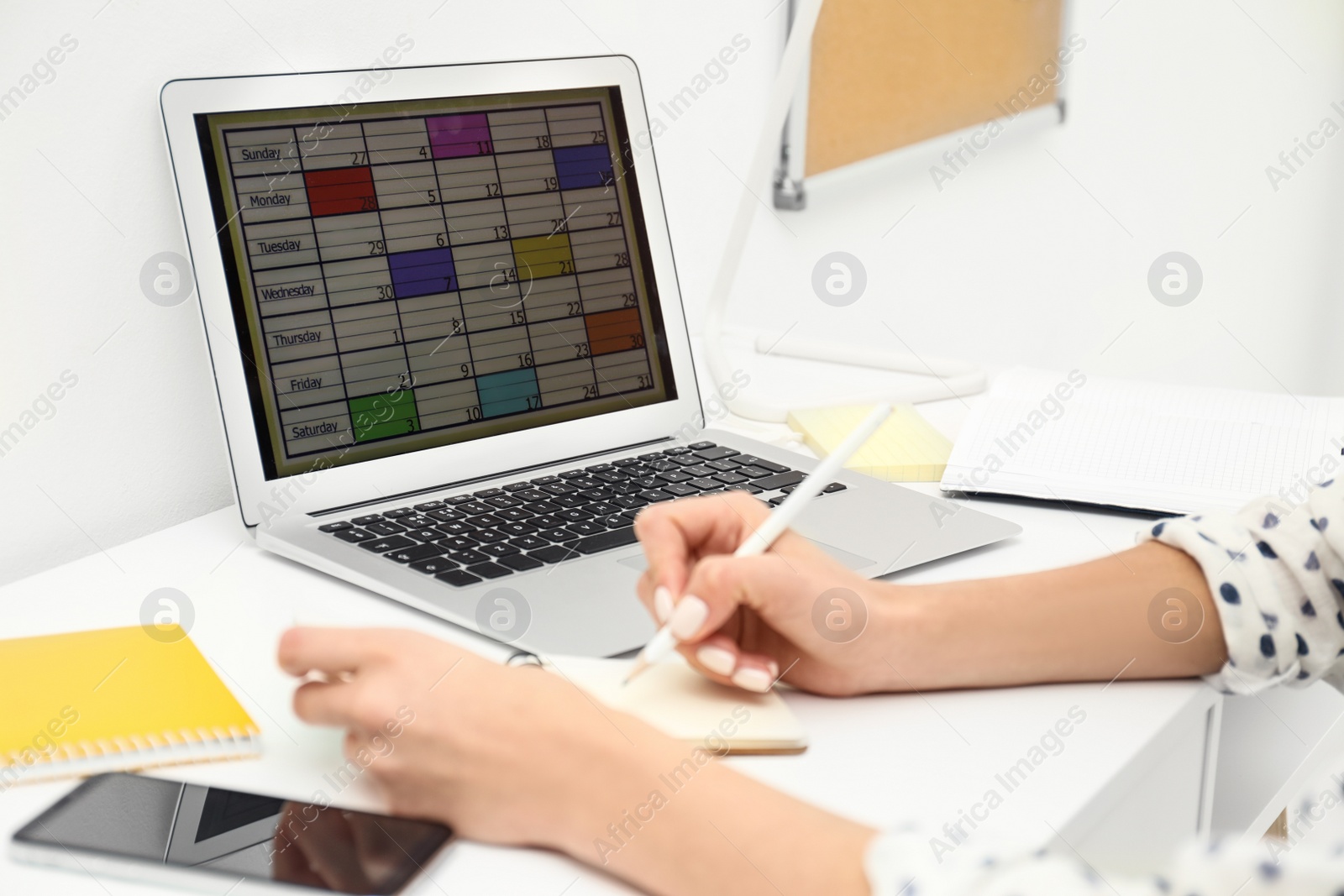 Photo of Woman planning her schedule with calendar app on laptop in office, closeup