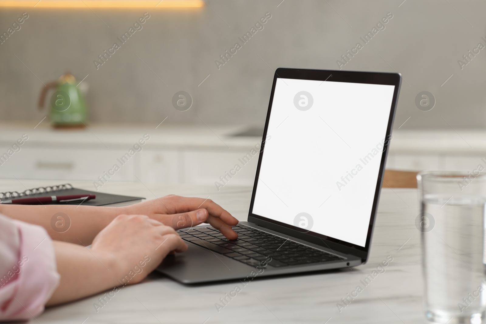 Photo of Woman using laptop at white table indoors, closeup