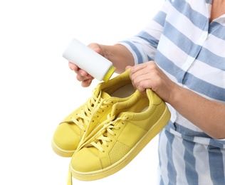 Photo of Woman putting powder shoe freshener in footwear on white background, closeup
