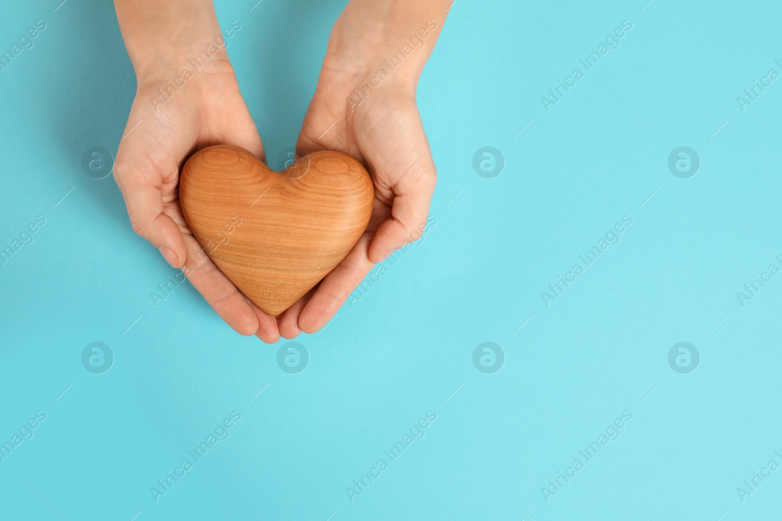 Photo of Woman holding decorative heart on color background, top view with space for text