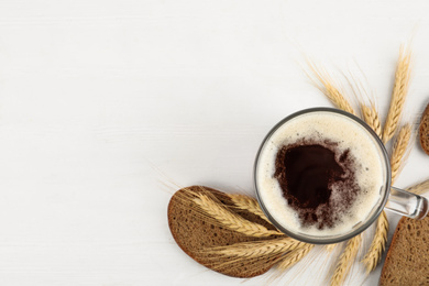 Photo of Flat lay composition with delicious kvass, spikes and bread on white wooden table. Space for text