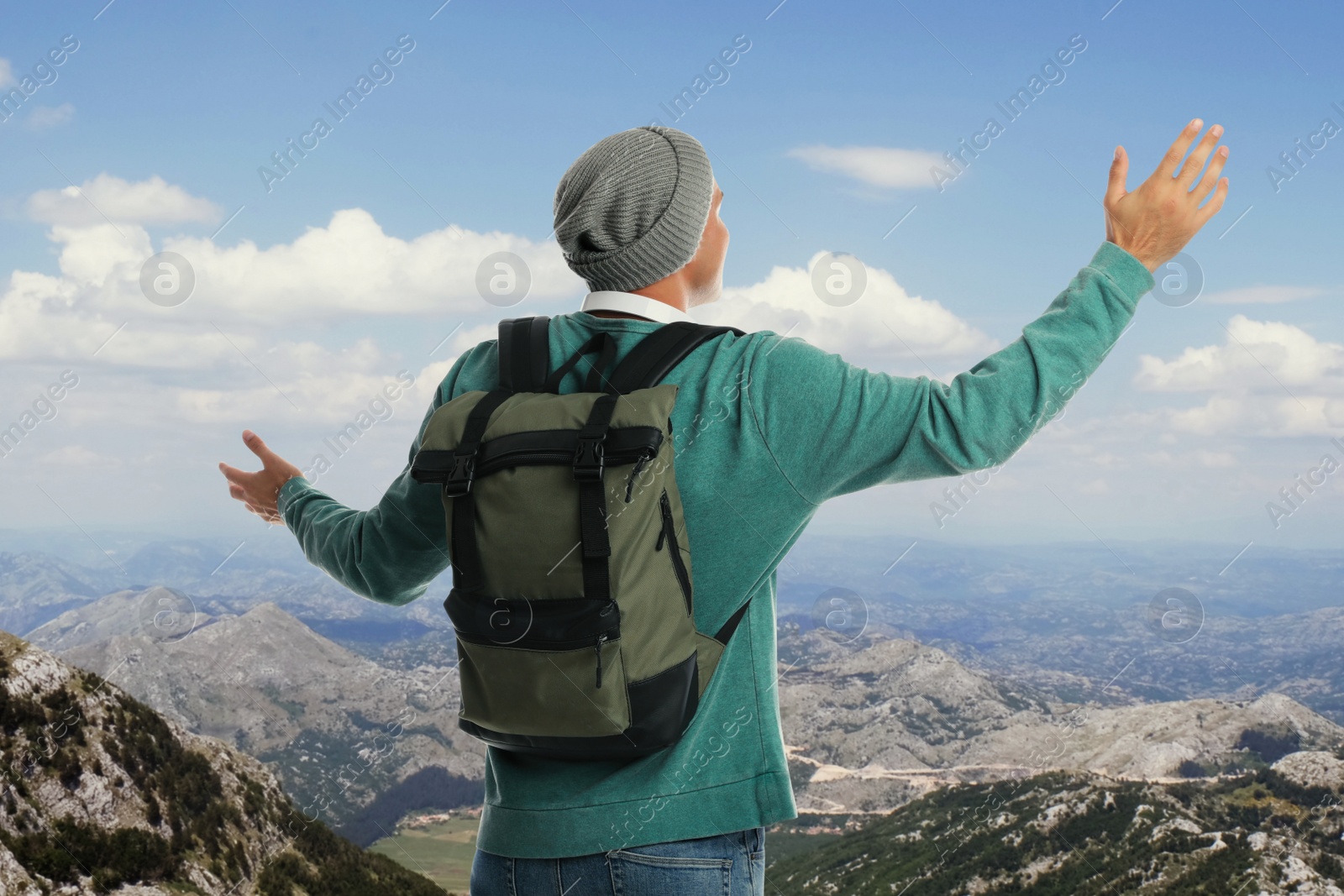 Image of Tourist with travel backpack enjoying mountain landscape during vacation trip