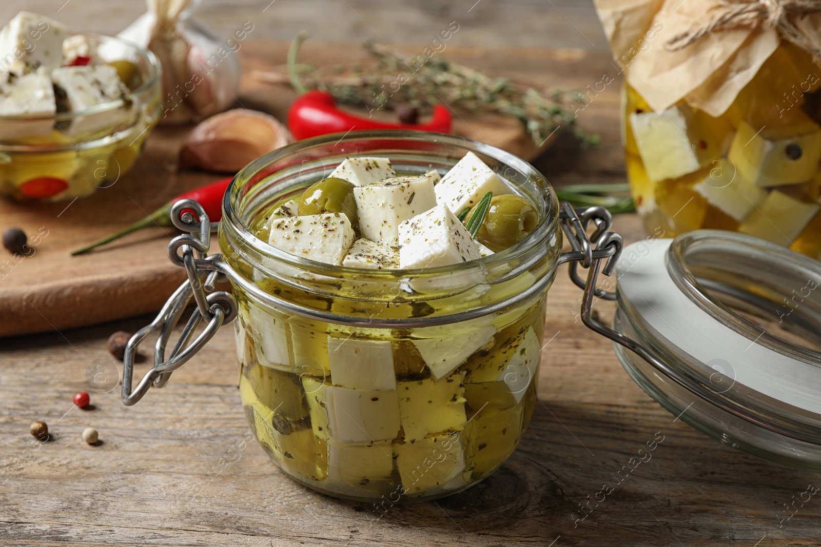 Photo of Composition with pickled feta cheese in jar on wooden table